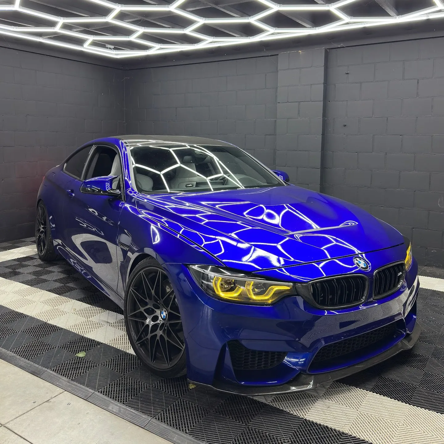 Blauwe BMW M4 onder de hexagon-verlichting van UCC